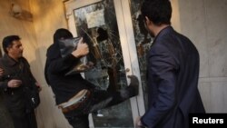 A protester kicks a door in the British Embassy compound in Tehran on November 29, 2011.