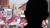 Ребенок смотрит из окна на демонстрантов, протестующих против соглашения Белграда и Приштины. Митровица, 22 апреля 2013 года.