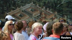 Turisti prolaze pored plakata na kojemu je prikaz Dioklecijanove palače, Split, fotoarhiv